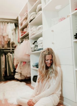 Blogger Erika Altes sitting in her girly themed walk in closet