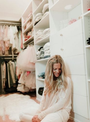 Blogger Erika Altes sitting in her girly themed walk in closet