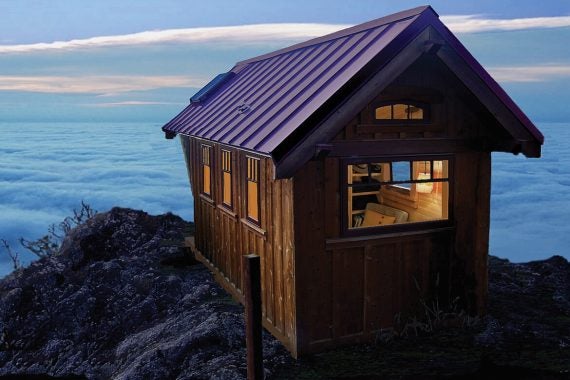 Small cottage on cliffside above the fog