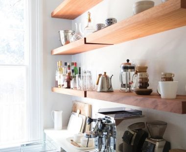 Clean white kitchen with wooden shelving and white cabinets