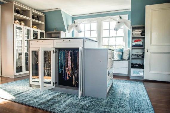 Spacious walk in closet with center jewelry storage in light grey finish