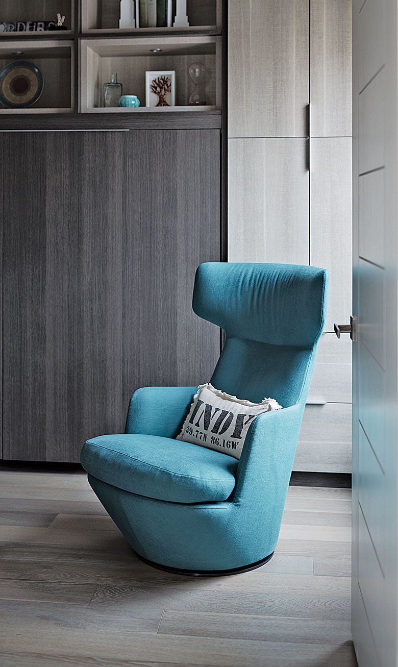 Blue chair in Indianapolis guestroom with Adriatic finish storage solutions