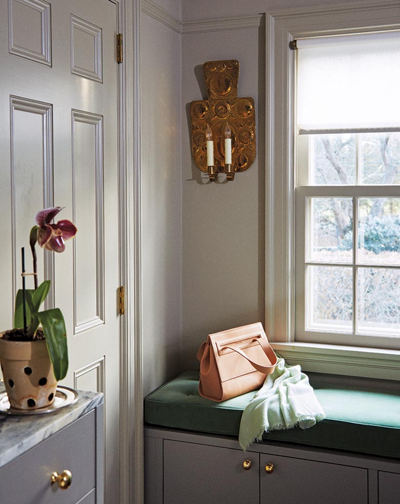 The collector dark gray cabinets with brass hardware and green fabrics