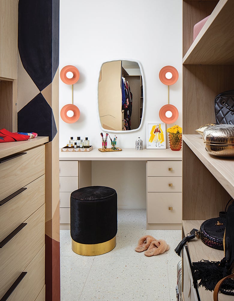 Ace Harper's walk in closet with custom shelves, drawers and built in vanity created by California Closets