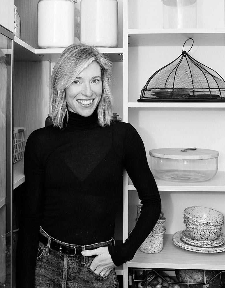 Erin Hiemstra standing in walk in closet designed in wood grain finish by California Closets