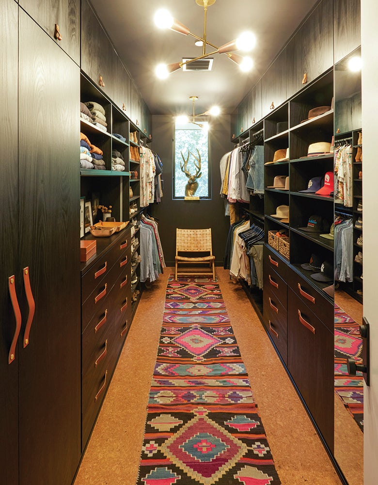John Rankins custom closet with cabinets, shelves and shoe storage in dark wood grain finish by California Closets