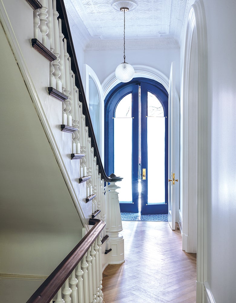 A luxury entryway with blue trimmed glass doors for Jon Batiste Brooklyn home photographed by California Closets